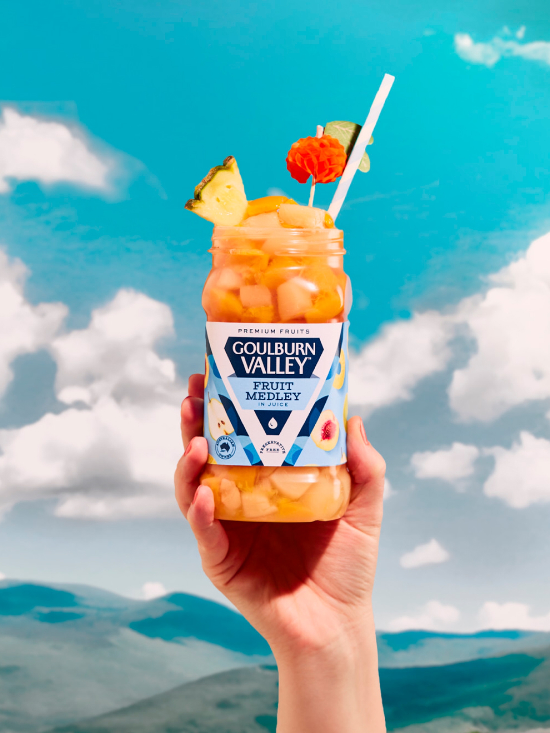 Hand holding up a jar of Goulburn Valley Fruit in front of landscape by packaging design agency by Our Revolution