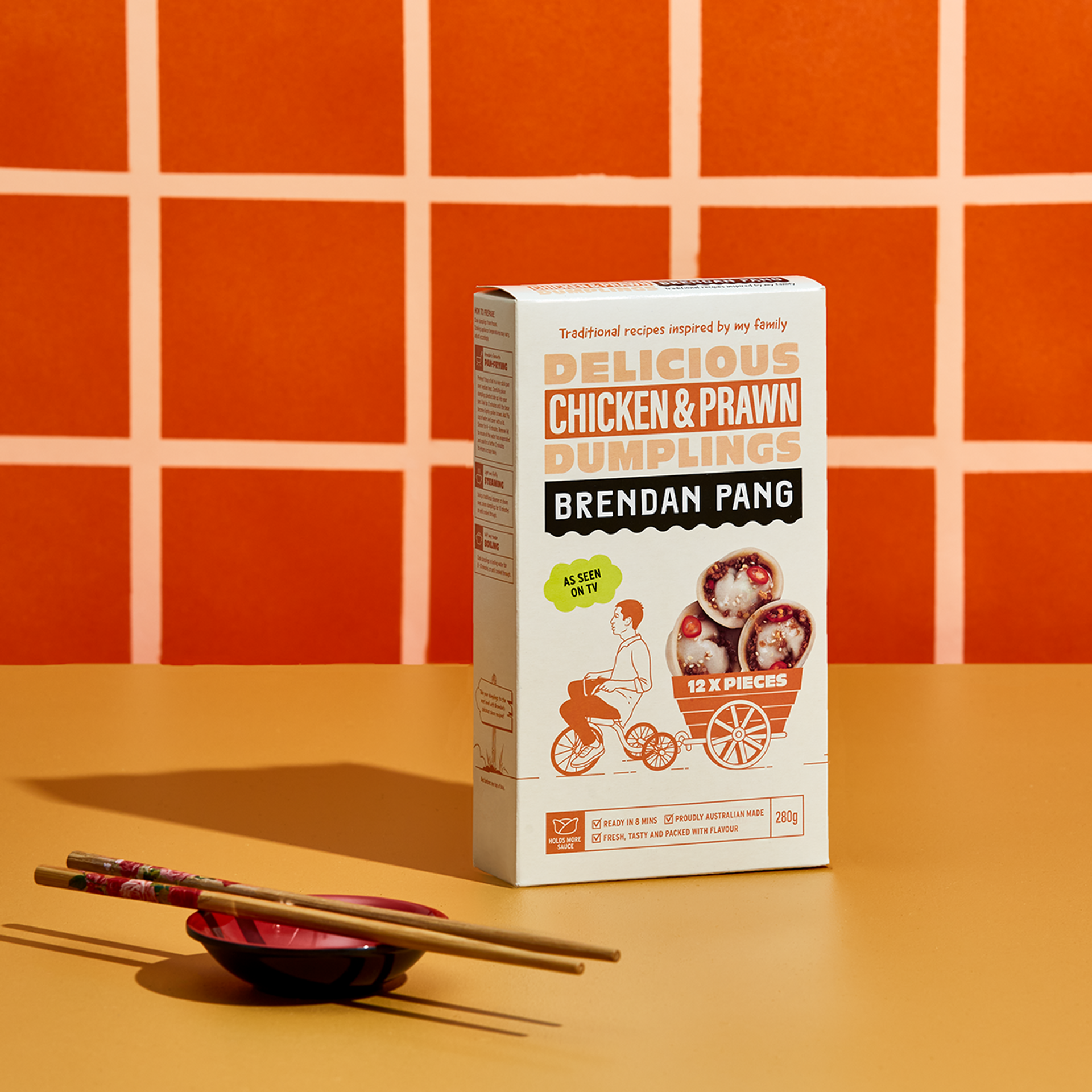 Dumpling packaging design in a bright, orange tiled kitchen featuring brand identity for Brendan Pang designed by creative agency Our Revolution