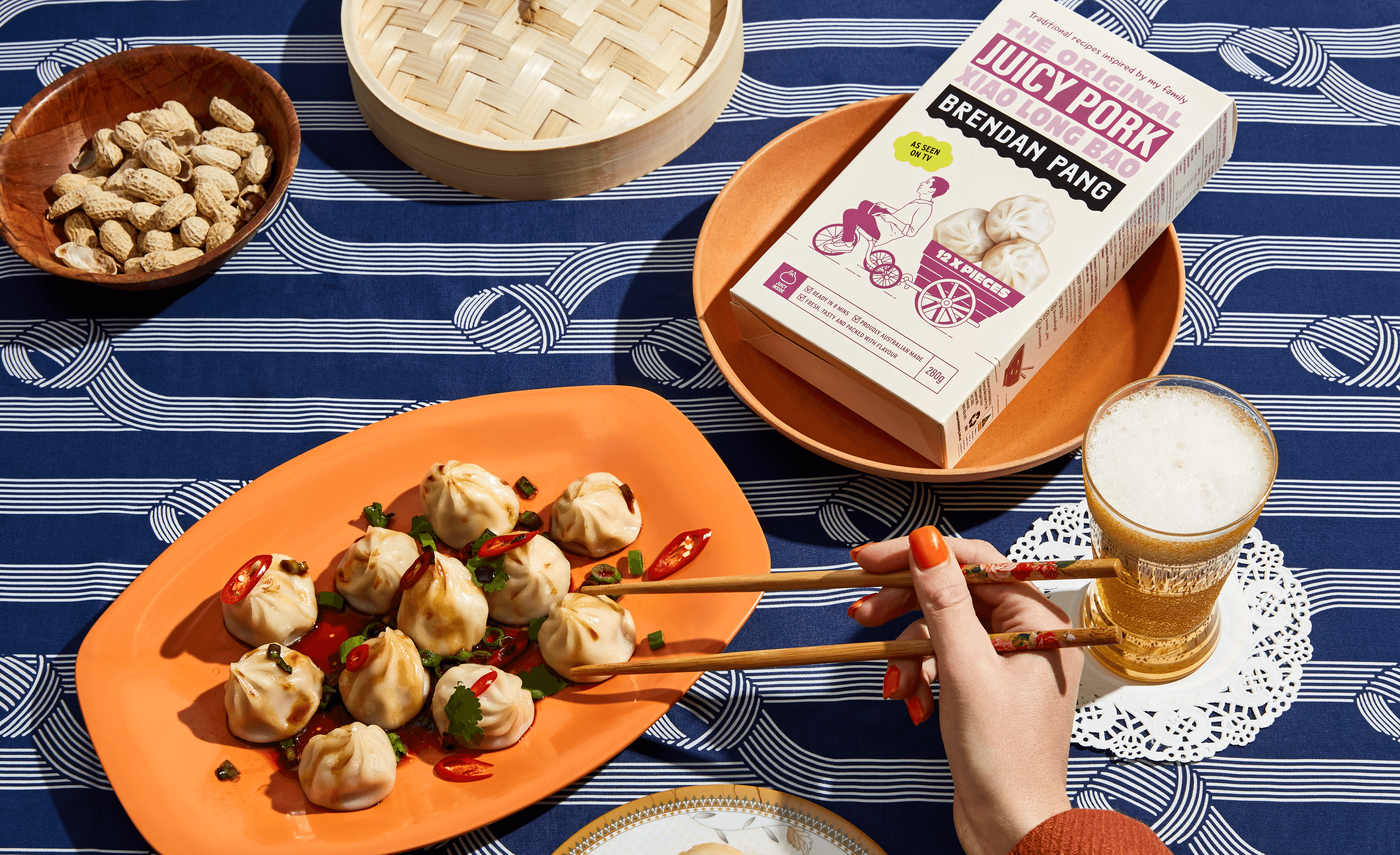Hand using chopsticks to eat dumplings for Brendan Pang dumpling brand, featuring packaging design by Our Revolution in London and Sydney