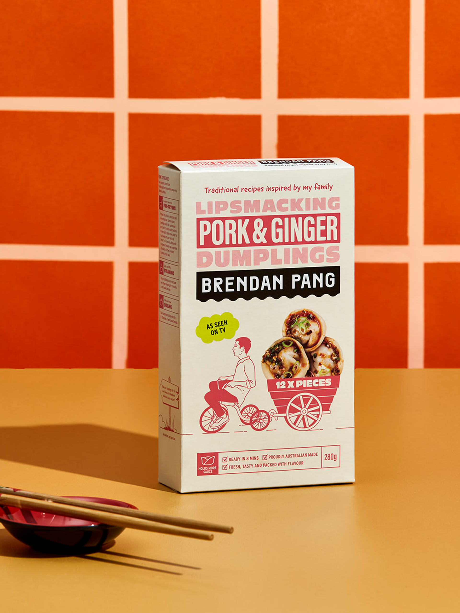 Pork dumplings packaging design in a bright, orange tiled kitchen featuring brand identity and design for Brendan Pang created by branding agency Our Revolution