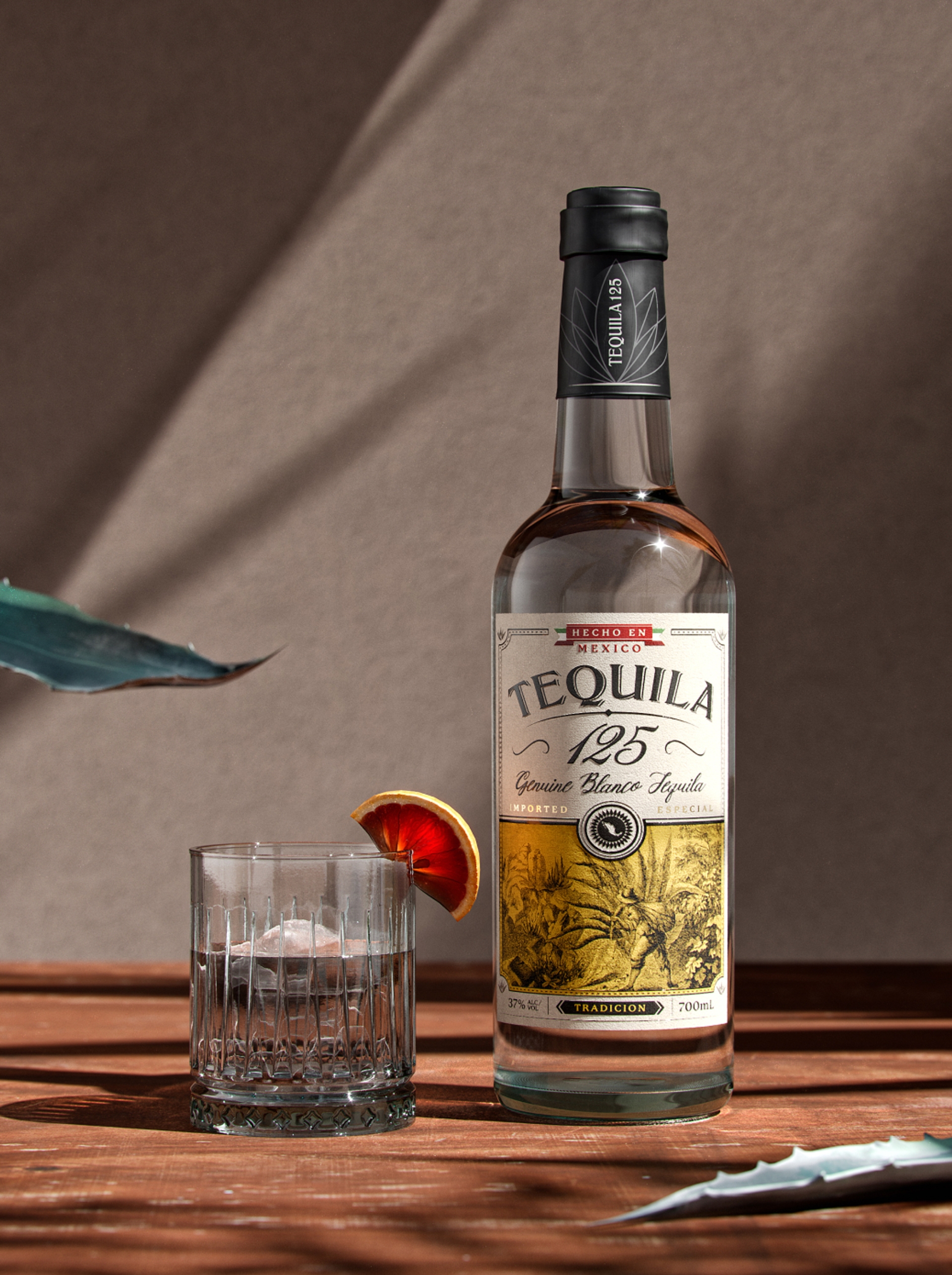 A bottle of Tequila 125 on a wooden table with a glass of tequila, brand and packaging design by Sydney London design agency Our Revolution Jen Doran